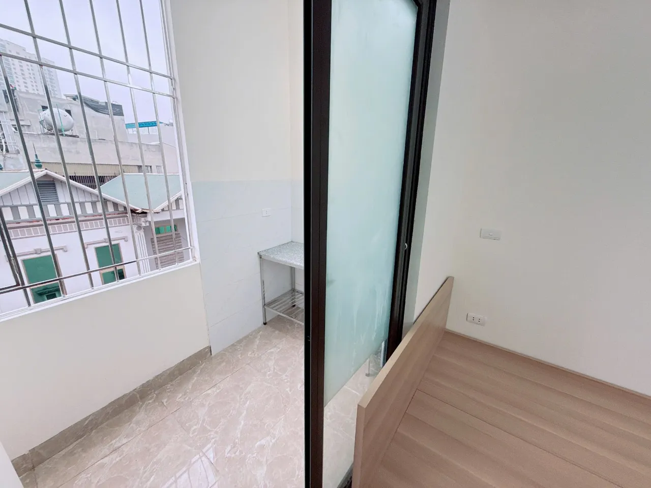 Góc nhìn từ giường ngủ ra ban công qua cửa kính.
