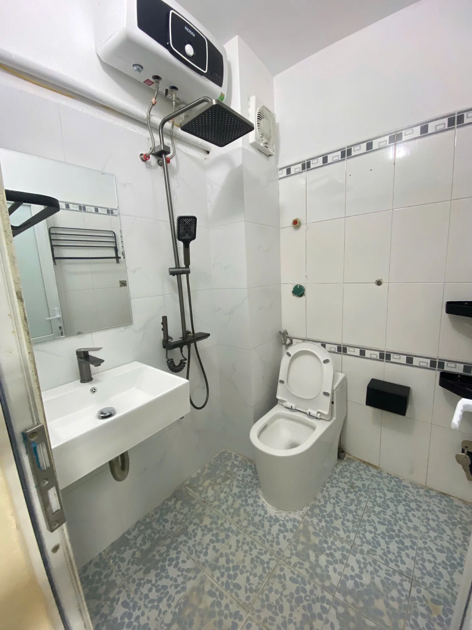 Phòng vệ sinh có bồn rửa tay, bồn cầu và vòi sen.