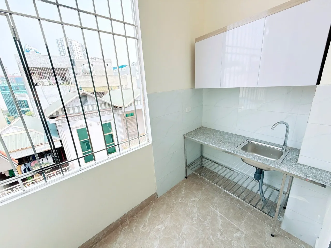 Khu vực bếp nấu ăn cạnh cửa sổ có bồn rửa.