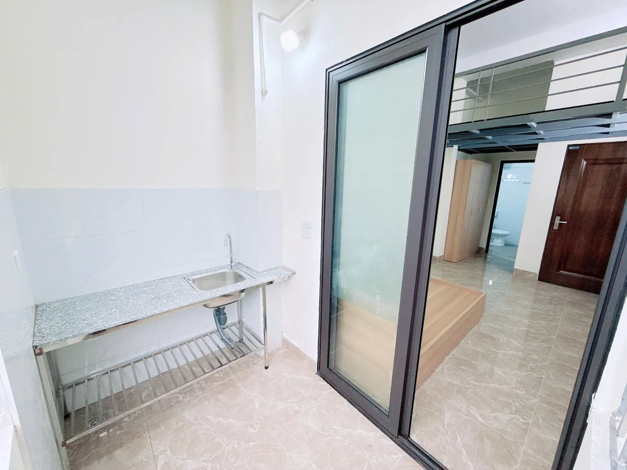 Cửa kính lùa ngăn giữa phòng ngủ và ban công bếp.