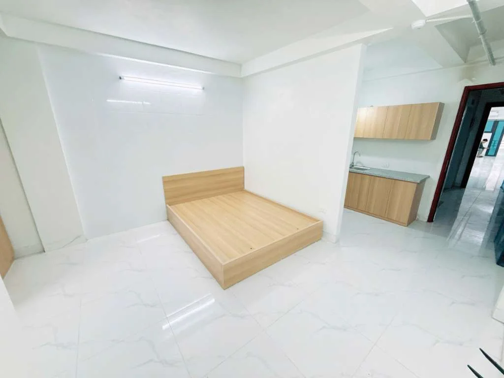 Giường ngủ bằng gỗ trong phòng cạnh kệ bếp