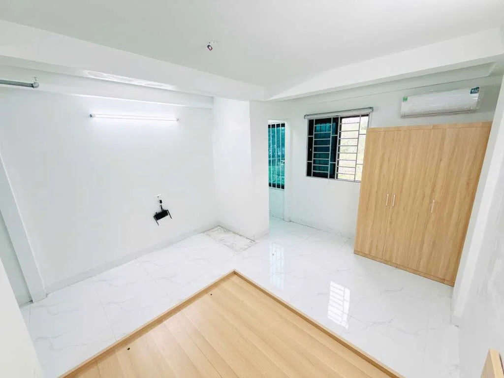 Phòng ngủ sáng sủa có giường gỗ và tủ quần áo