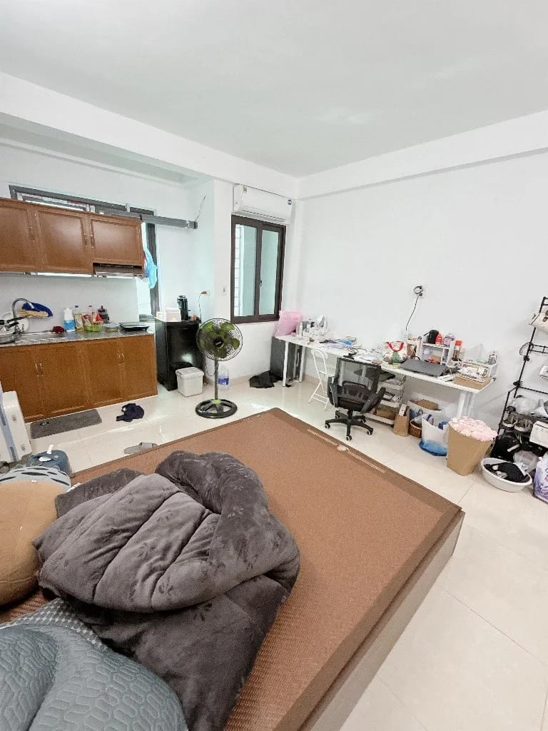 Phòng trọ có giường ngủ lớn, bàn làm việc và tủ bếp